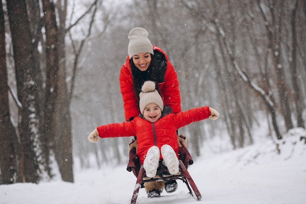 Mutter mit tochter im winterparkrodeln