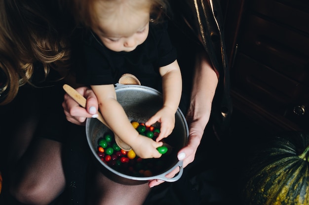 Mutter mit Tochter in den Armen und ist mit den Händen zwischen den Bonbons