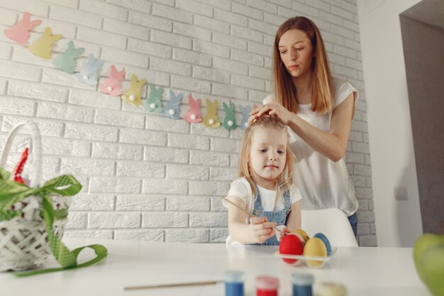 Mutter mit Tochter in einer Küche, die Ostern vorbereitet