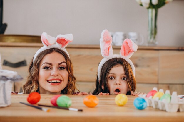 Mutter mit Tochter malt Eier für Ostern