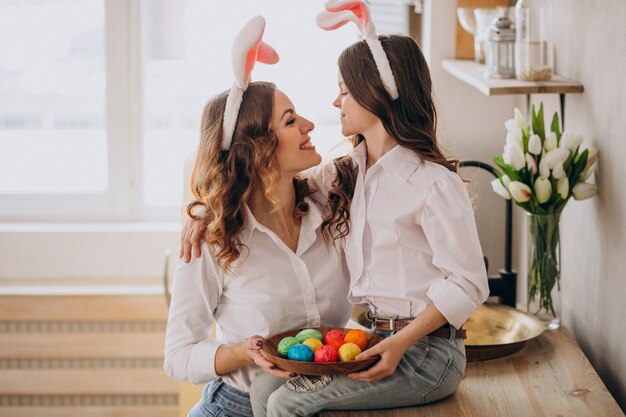 Mutter mit Tochter malt Eier für Ostern