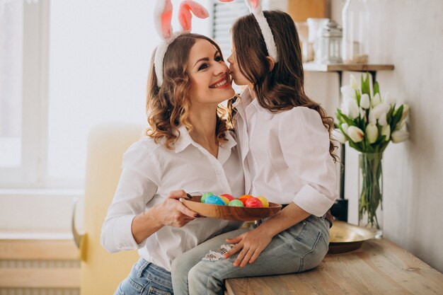 Mutter mit Tochter malt Eier für Ostern