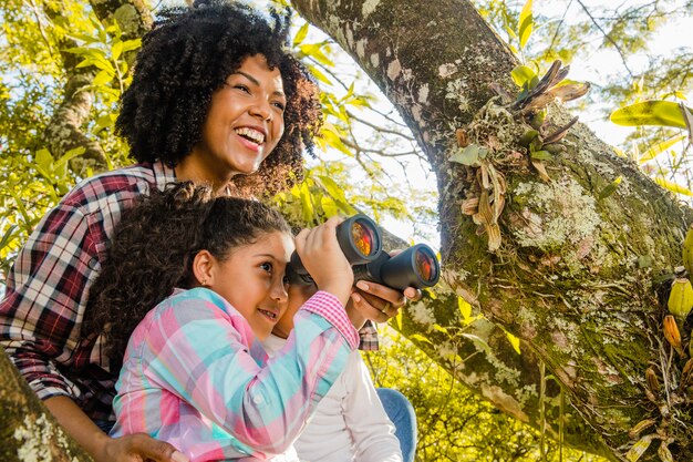 Mutter mit Tochter neben einem Baum