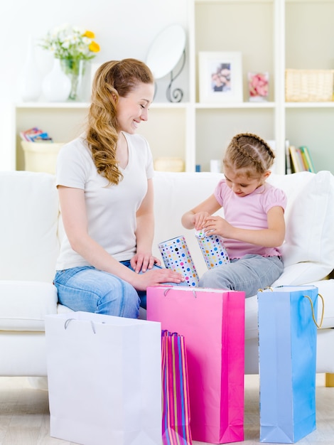 Mutter mit Tochter öffnet Geschenk