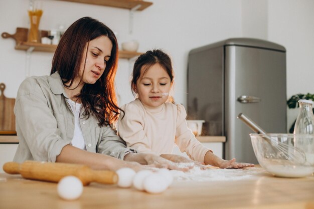 Mutter mit Tochter spielt mit Mehl und backt in der Küche