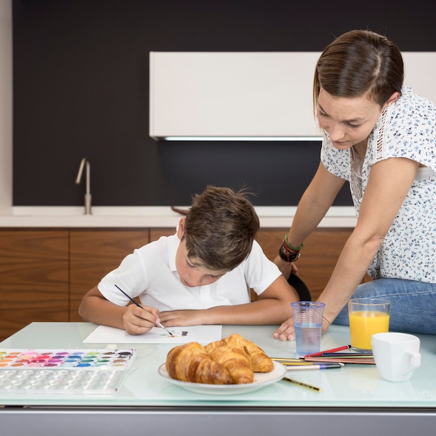 Mutter prüft Söhne, die zu Hause malen