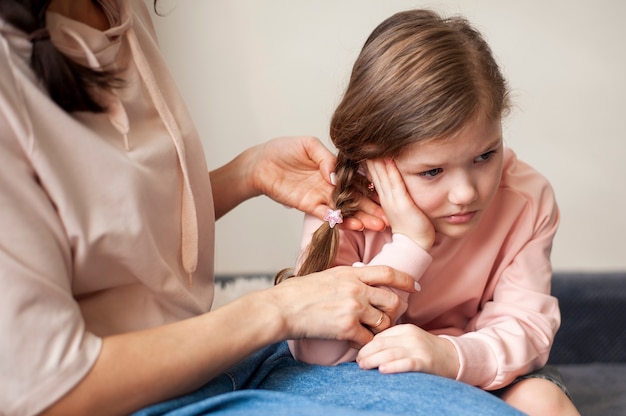 Mutter schneidet ihre jungen Mädchen Haare