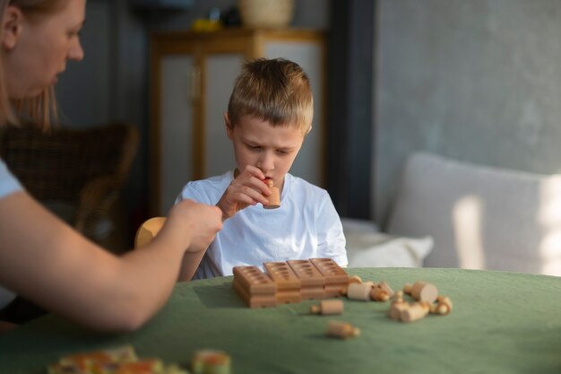 Mutter spielt mit ihrem autistischen Sohn mit Spielzeug