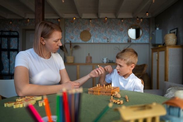 Mutter spielt mit ihrem autistischen Sohn mit Spielzeug