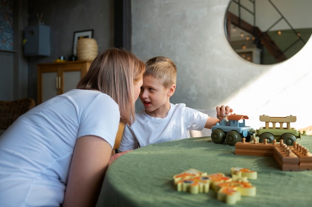 Mutter spielt mit ihrem autistischen Sohn mit Spielzeug