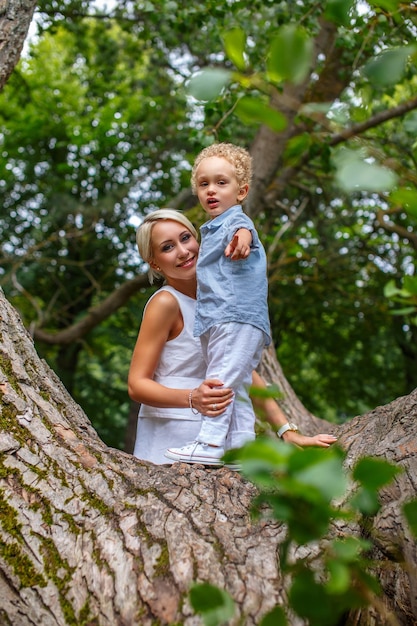 Mutter spielt mit ihrem Kind auf Baum im Park.