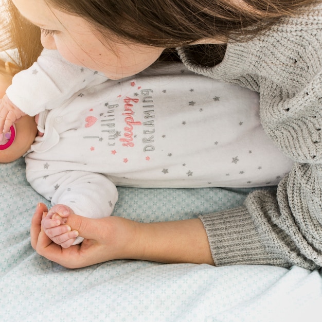 Kostenloses Foto mutter und baby händchen haltend auf bett