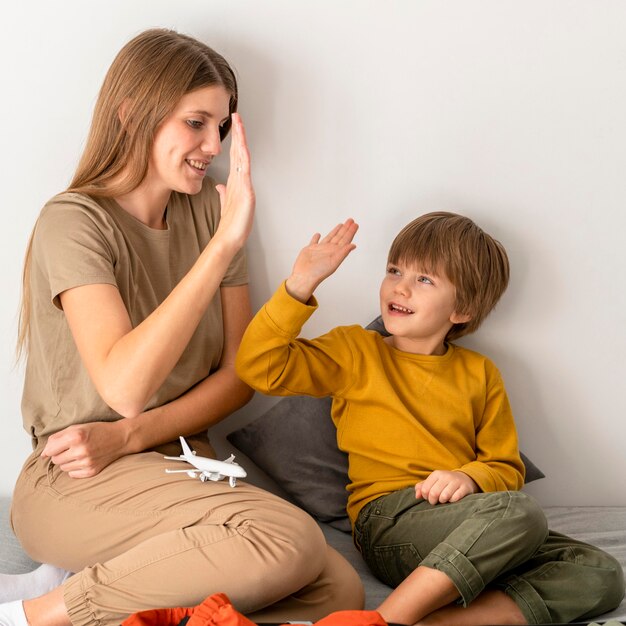 Mutter und High-Fiving einander, während sie ihr Gepäck für die Reise vorbereiten