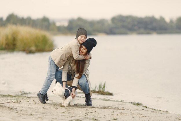 Mutter und ihre Tochter spielen mit Hund. Haustier-, Haustier- und Lebensstilkonzept