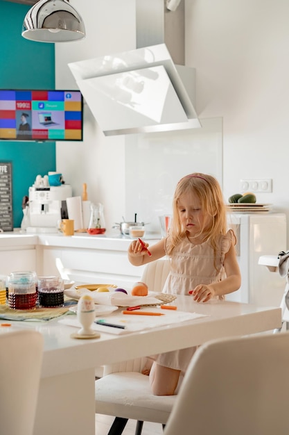 Mutter und ihre Töchter bemalen Eier. Glückliche Familie bereitet sich auf Ostern vor.