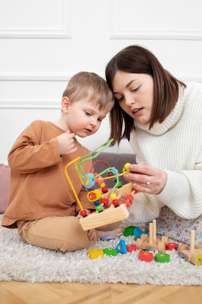 Mutter und Kind mit mittlerer Aufnahme und Lernspiel