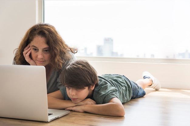 Mutter und Kind suchen auf Laptop