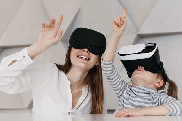 Mutter und Kind verwenden Virtual-Reality-Headset und zeigen nach oben