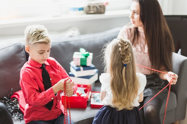 Mutter und Kinder auf Couch am Weihnachten