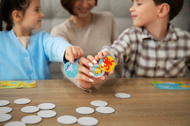 Mutter und Kinder spielen Memory-Spiel Vorderansicht