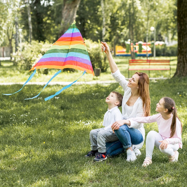 Mutter und Kinder spielen mit Drachen