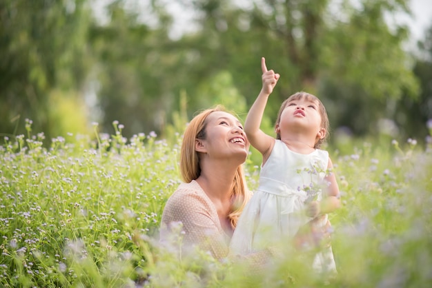 Mutter und kleine Tochter, die zusammen in einem Park spielen