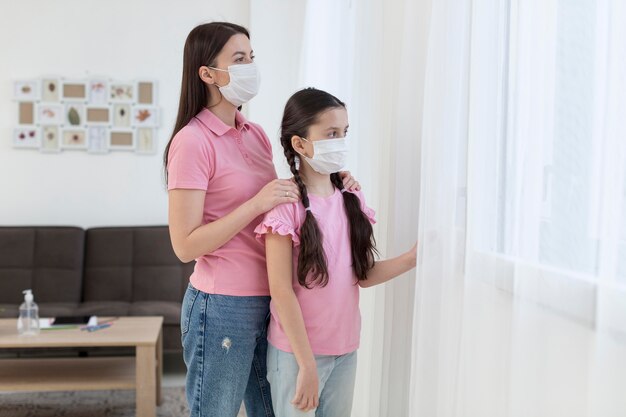 Mutter und Mädchen schauen aus dem Fenster