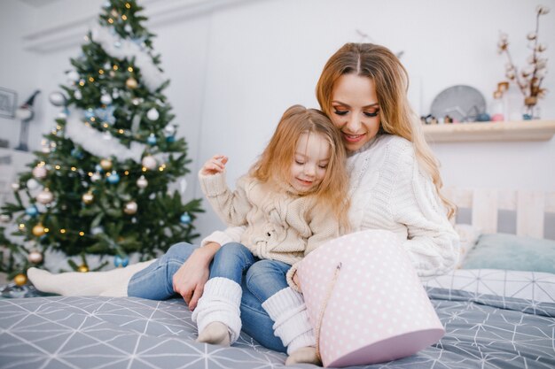 Mutter und schöne blonde Baby Mädchen Eröffnung Geschenke