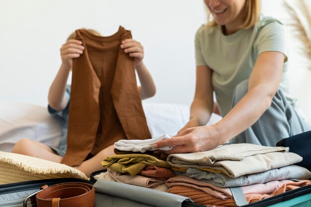 Mutter und Sohn bereiten einen Koffer für ihren Urlaub vor