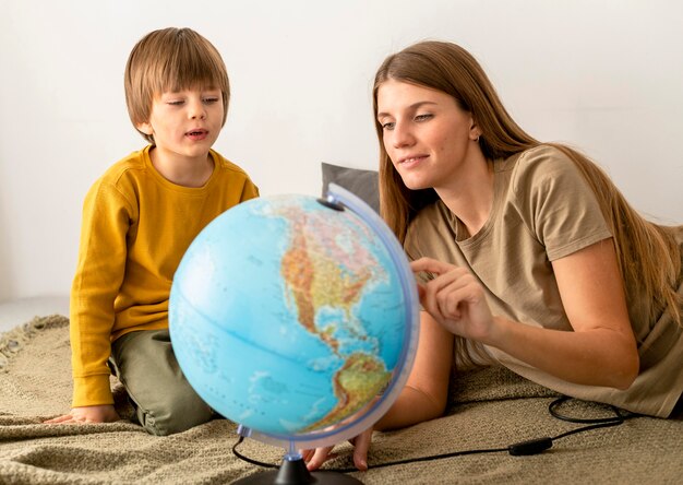 Mutter und Sohn betrachten Globus zusammen