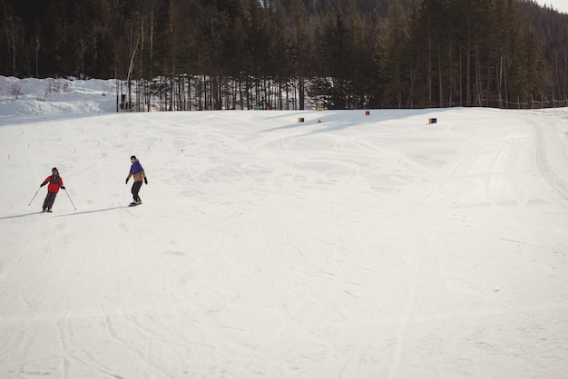 Mutter und Sohn fahren auf schneebedeckten Alpen Ski