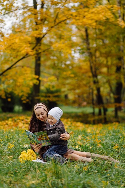 Mutter und Sohn gehen spazieren und haben gemeinsam Spaß im Herbstpark.