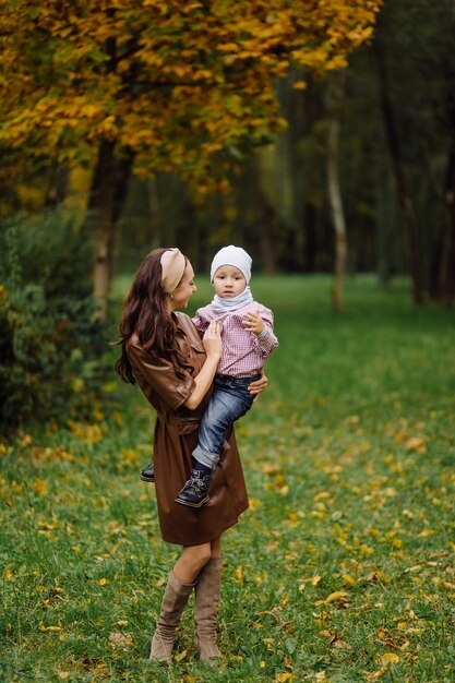 Mutter und Sohn gehen spazieren und haben gemeinsam Spaß im Herbstpark.