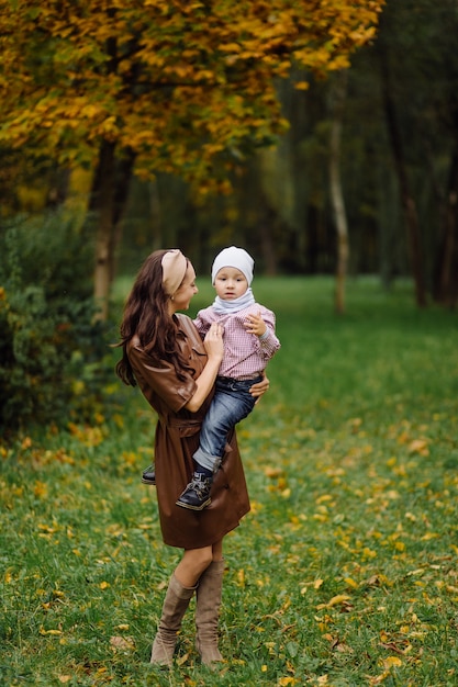 Mutter und Sohn gehen spazieren und haben gemeinsam Spaß im Herbstpark.