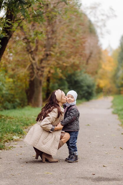 Mutter und Sohn gehen spazieren und haben gemeinsam Spaß im Herbstpark.