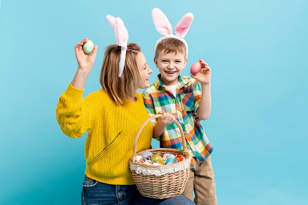 Kostenloses Foto mutter und sohn halten bemaltes ei