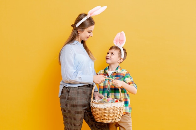 Kostenloses Foto mutter und sohn mit korb mit bemalten eiern