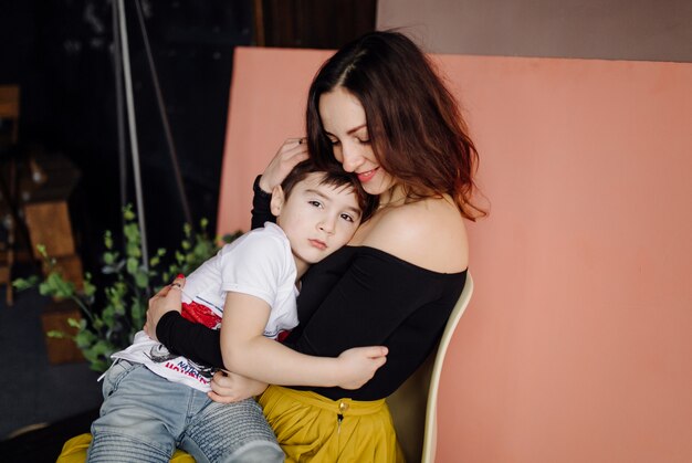 Mutter und Sohn posieren im Studio und tragen Freizeitkleidung