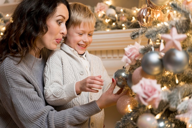 Mutter und Sohn schmücken den Weihnachtsbaum