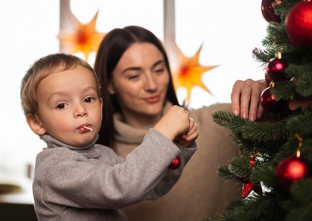 Mutter und Sohn schmücken den Weihnachtsbaum