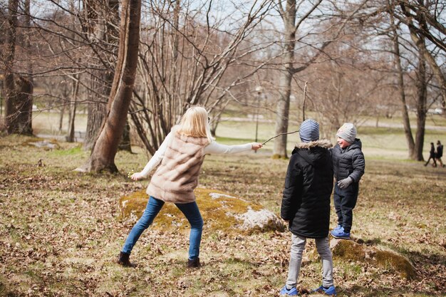 Kostenloses Foto mutter und sohn spielen mit stöcken im park