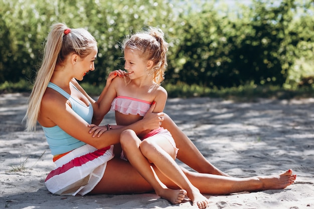 Mutter und Tochter am übenden Yoga des Strandes