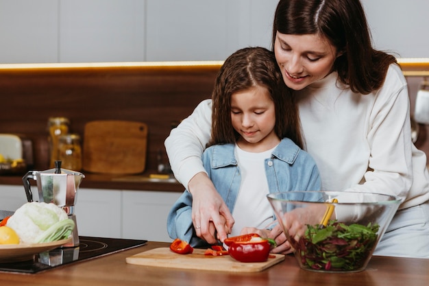 Mutter und Tochter bereiten Essen in der Küche zu