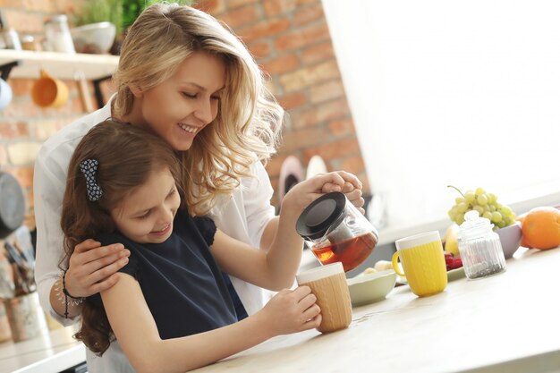 Mutter und Tochter bereiten Teetasse vor