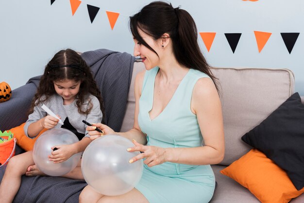 Kostenloses Foto mutter und tochter, die auf ballone zeichnen