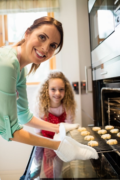 Mutter und Tochter, die Cookies in Küche zubereiten