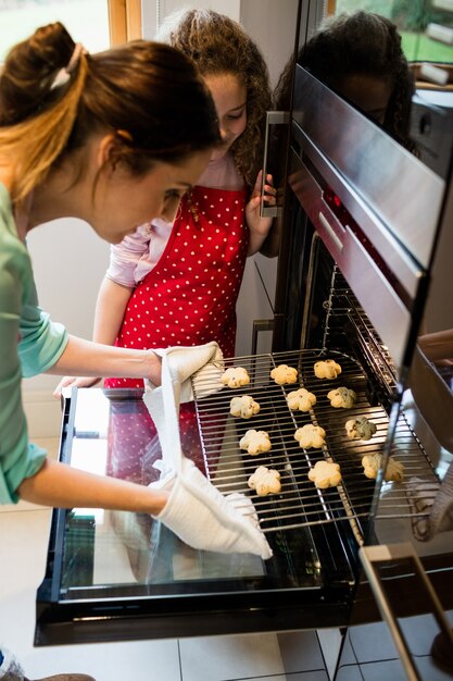 Mutter und Tochter, die Cookies in Küche zubereiten