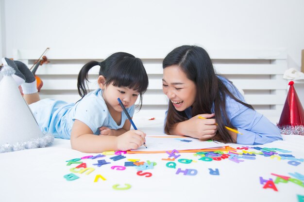 Mutter und Tochter, die das Alphabet studieren