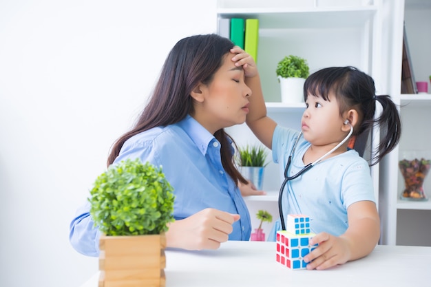 Mutter und Tochter, die Doktor mit Stethoskop spielen