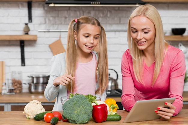 Mutter und Tochter, die eine digitale Tablette betrachten